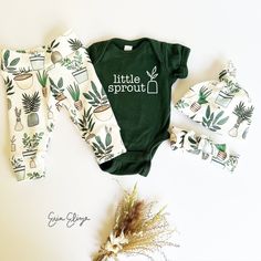 a baby's green and white outfit with potted plants on it, along with matching headbands