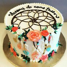 a cake decorated with flowers and feathers is on a silver platter that says, always do come true