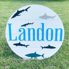 a sign that says landon with sharks on it in front of some trees and grass