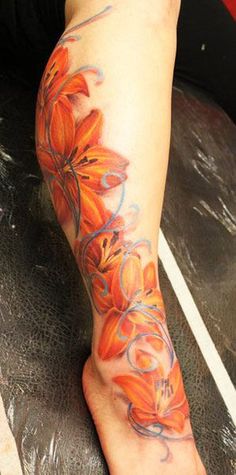 an orange flower tattoo on the left leg and right foot, with blue swirls around it