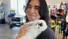 a man holding a small white rabbit in his arms