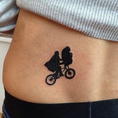 a woman's stomach with a small tattoo of a bicyclist on it