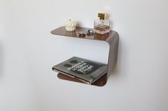 two shelves with books and perfume bottles on them