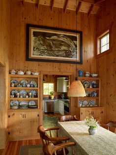 a dining room with wooden walls and wood flooring