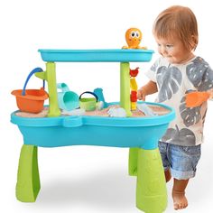 a toddler playing with a sand and water table