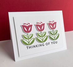 a card with three flowers and the words thinking of you