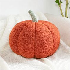 a large orange pumpkin sitting on top of a bed