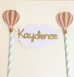 two hot air balloons with the word kaydence on them are next to some straws