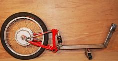 a red bicycle wheel is attached to a wooden wall