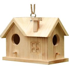 a wooden birdhouse with two windows and a cross on the roof, hanging from a rope