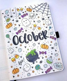 an open notebook with the word october written in black on it and lots of halloween decorations