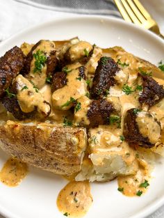 a white plate topped with potatoes covered in gravy