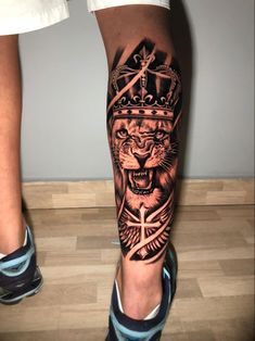 a man's leg with a lion and crown tattoo on it