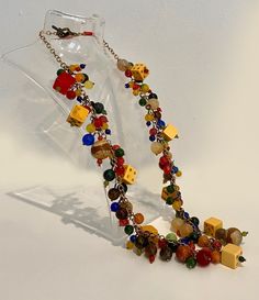 Length: 24" Long Weight: 156g / 5.5oz Size of beads: 6-18 mm Material: gemstones, yellow and red bakelite dice, vintage brass corrugated beads Cable chain: solid brass Style/character: Cluster statement Main color: Red, Yellow All beads are safely secured to the chain. Vintage Gold Jewelry With Wooden Beads, Multicolor Brass Beaded Necklaces As Gift, Multicolor Round Bead Brass Necklace, Multicolor Brass Necklace With Round Beads, Multicolor Round Beads Brass Necklace, Unique Gold Jewelry With Wooden Beads, Vintage Multicolor Wooden Beads Jewelry, Vintage Amber Jewelry With Colorful Beads, Vintage Polished Yellow Beads Jewelry