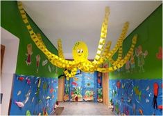 a hallway decorated with yellow and green paper streamers in the shape of octopuses