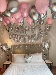 balloons and streamers are hanging above the bed in this bedroom decorated for a birthday