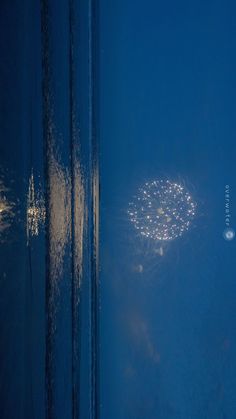 fireworks are lit up in the night sky from inside an airplane window as it flies by