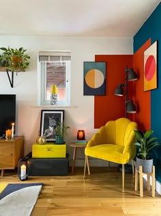 a living room filled with furniture and colorful wall art on the walls next to a fire place