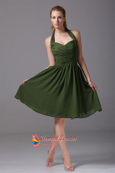 a woman in a green dress is posing for the camera with her hand on her hip