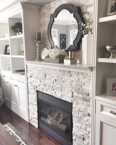 a living room with a fire place and bookshelves on the wall next to it