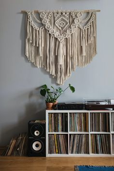 there is a record player in front of the wall hanging on the wall above it