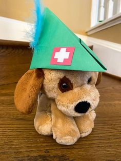 a stuffed dog wearing a green hat with a red cross on it's head