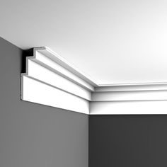 the corner of a room that is painted gray and has white trim around the edges