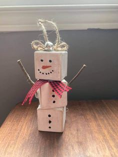 a snowman made out of toilet paper sitting on top of a wooden table