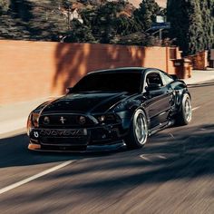 a black sports car driving down the road