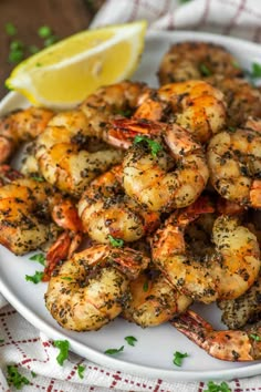 grilled shrimp on a plate with lemon wedges and parsley garnish