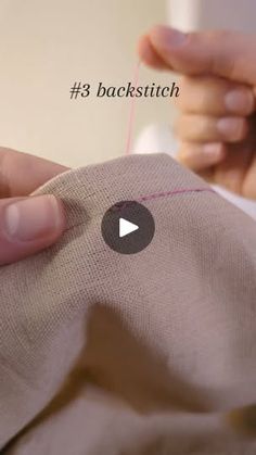 someone is stitching something on a piece of cloth