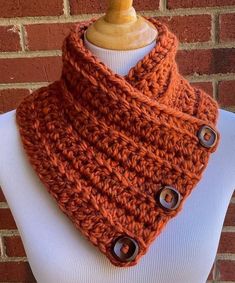 an orange crocheted cowl on top of a mannequin