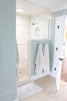 two white towels are hanging on the wall next to each other in front of a shower