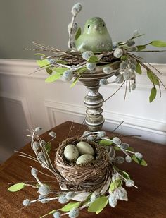 a bird's nest with eggs in it on top of a table next to a wall