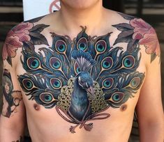 a man with tattoos on his chest has a peacock tattoo on it's chest