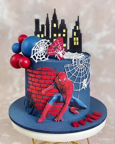 a spiderman birthday cake with red, white and blue decorations on it's side