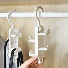 a person is holding two hooks on a coat rack