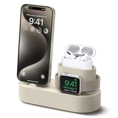 an apple watch and earbuds are sitting on a charging dock with the iphone in the background