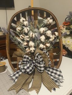 a bouquet of flowers sitting on top of a wooden chair next to a vase filled with flowers