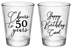 two shot glasses with the words cheers to 50 years printed on each one, both in black and white