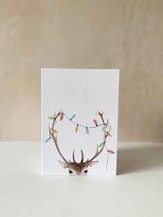 a card with an image of a deer's head and christmas lights on it