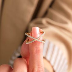 a woman is holding a ring in her left hand and the other hand has a diamond band on it