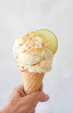 a person holding an ice cream cone with a lime slice on top