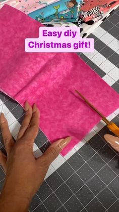 someone is making a christmas gift with pink paper