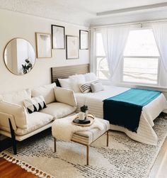 a living room with a couch, ottoman and bed