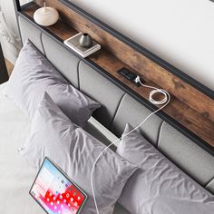 a bed with two pillows and an electronic device hooked up to the headboard