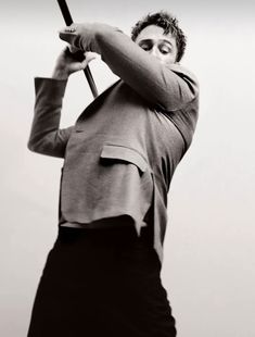 a black and white photo of a man holding a baseball bat in his right hand