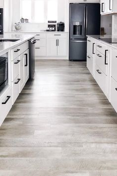 a kitchen with white cabinets and black appliances