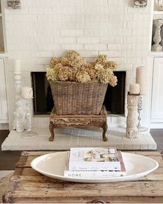 a basket with flowers sitting on top of a table in front of a fire place