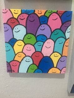 a painting of many smiling faces on a white wall